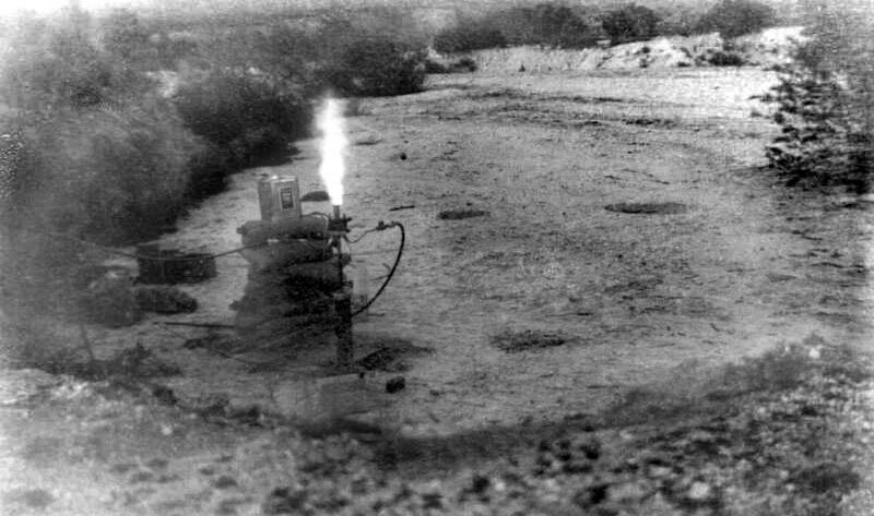 A small rocket motor firing on its stand in the dry wash of the Arroyo Seco